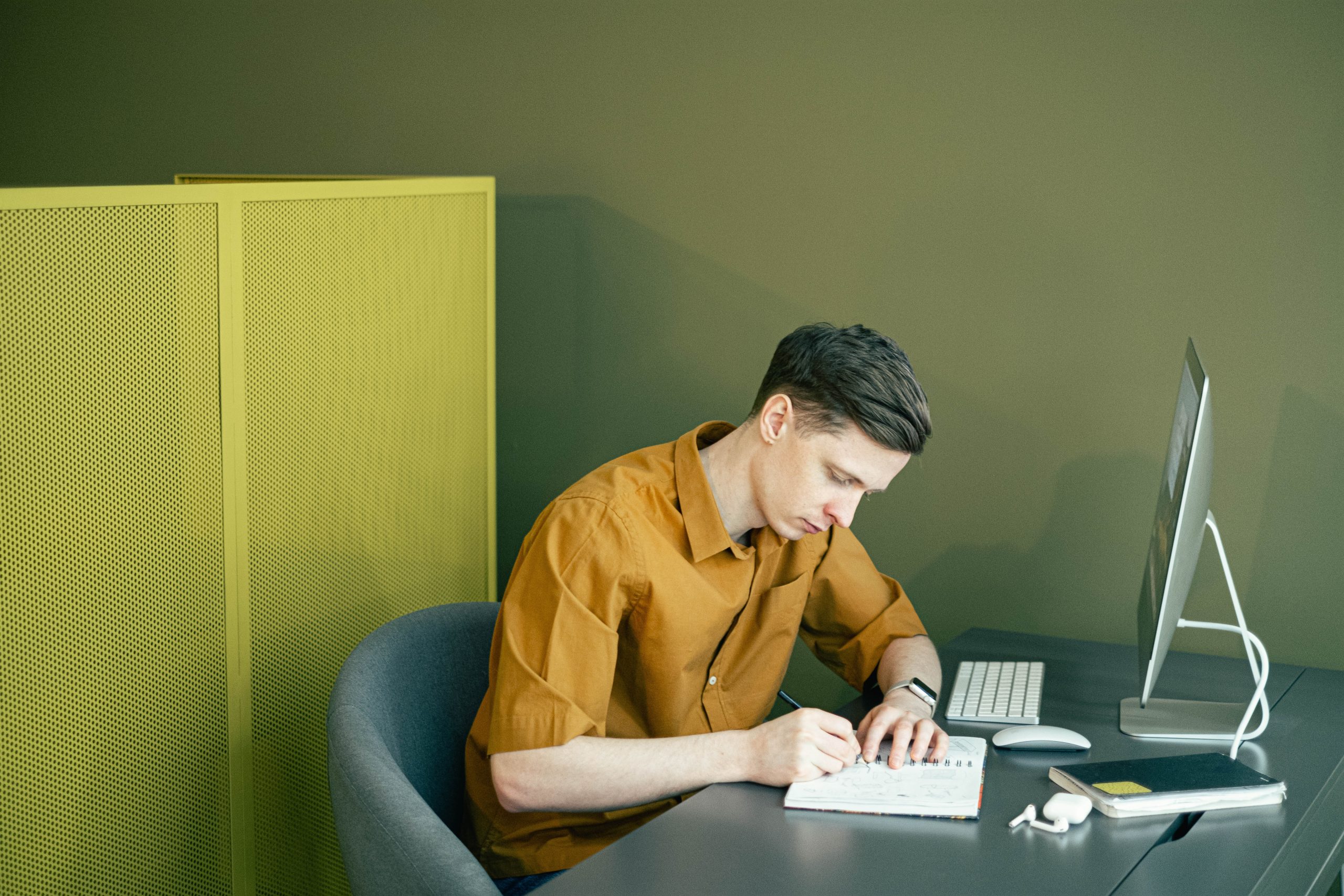 Man Taking Notes in front of his Computer