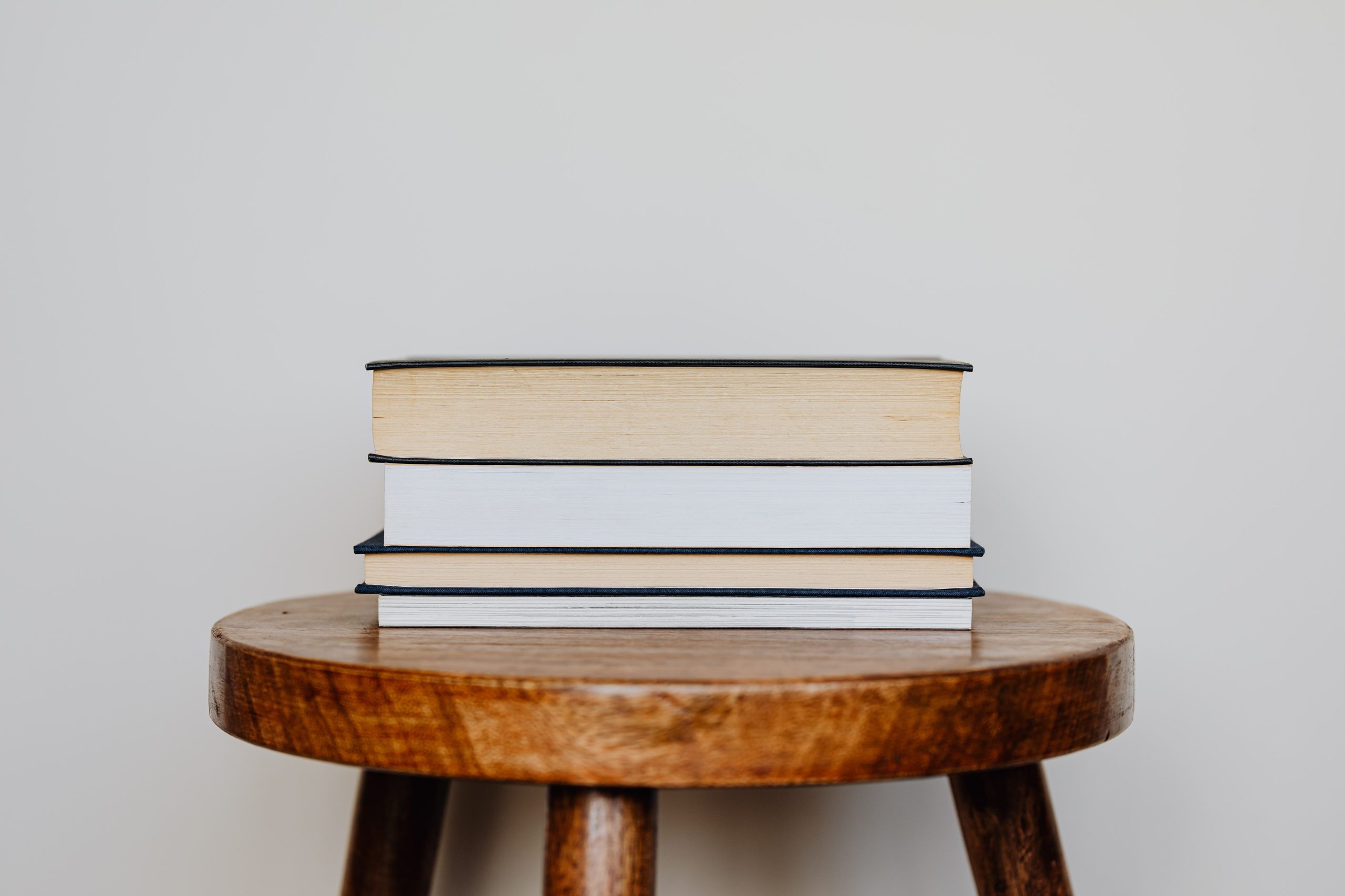 Close-Up Photo of Stack of Books on Wooden Stool