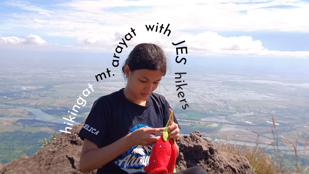 woman on the top of the mountain crocheting