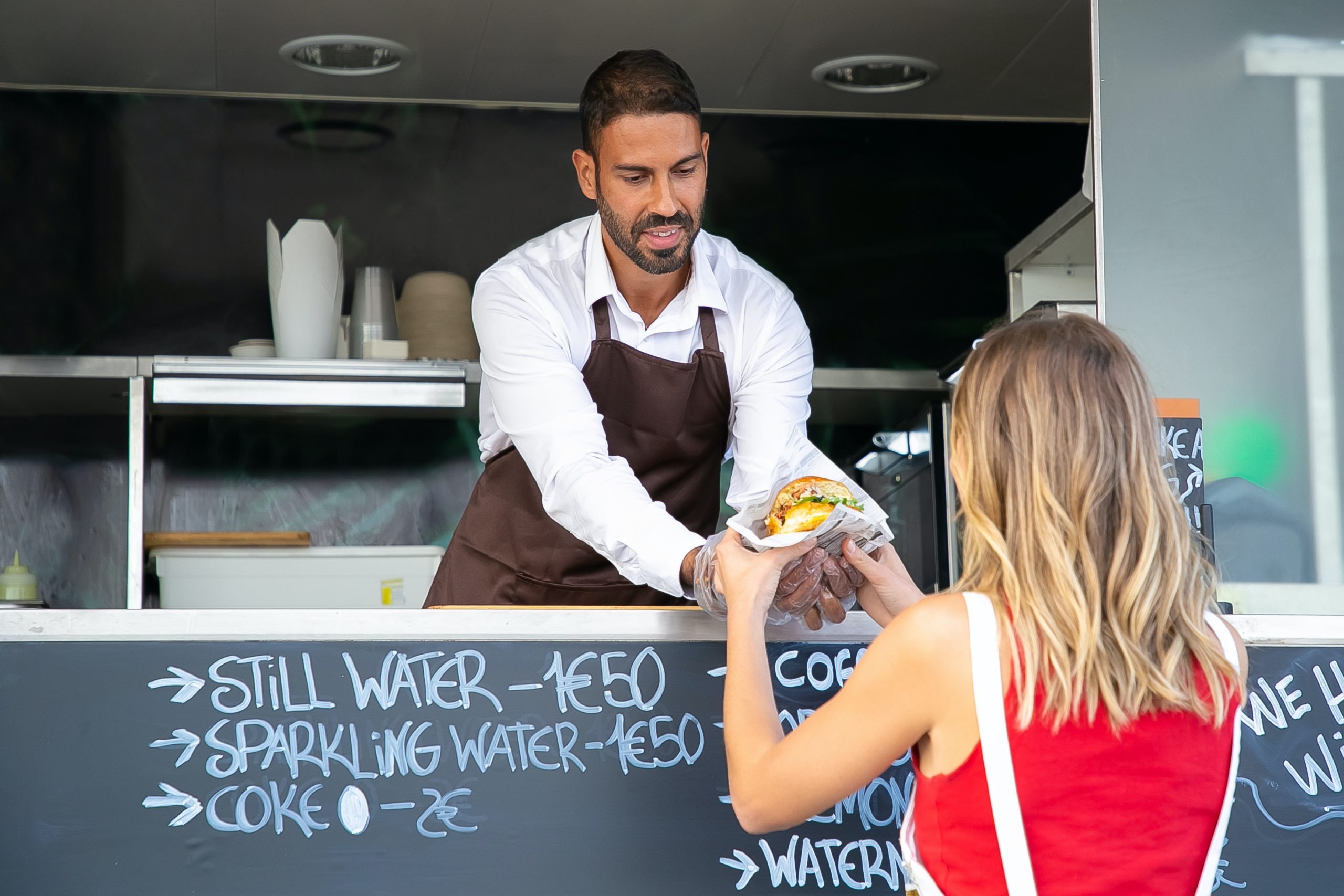 Female buying tasty burger in food truck